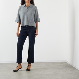 Model wearing FRAME DENIM Graphite Grey cashmere polo top with dark navy cropped jeans and black kitten heel shoes.