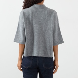 Model wearing FRAME DENIM Graphite Grey cashmere top, back view, boxy crop fit with mock neck and short sleeves, styled with dark jeans