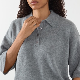 Model wearing FRAME DENIM Graphite Grey cashmere polo top, featuring a ribbed collar, three-button placket and relaxed fit.