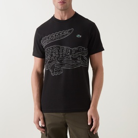 Model wearing Lacoste Crew Neck T in black with large outline crocodile graphic print, styled with khaki cargo trousers.