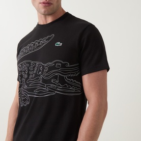 Model wearing Lacoste Crew Neck T in black with large outlined crocodile graphic print in white across the chest.