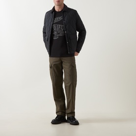 Model wearing Lacoste Black/White Crew Neck T-shirt, styled with dark quilted overshirt, olive cargo trousers and black shoes.