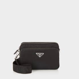 Prada black nylon crossbody bag with silver-tone triangle logo plaque, zip closure, and wide woven shoulder strap