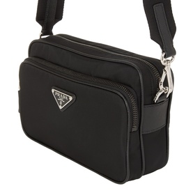 Prada black nylon crossbody bag with silver-tone triangle logo, zip closure, and adjustable webbing strap