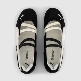 Puma Black ballet flats with white cross-strap detailing, OrthoLite insole visible, overhead flat-lay view