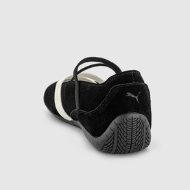 Puma black suede flat shoe, rear view showing ankle strap, Puma logo, and textured grey rubber sole