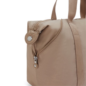Close-up of Kipling bag in beige, showing zip pocket detail, monkey keyring charm and short top handles with silver-tone hardware