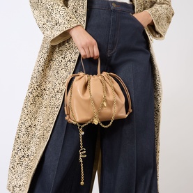 Model carrying Chloe Icons Leather Mini Crossbody Bag in Light Tan with gold-tone chain strap and foil logo detail, styled with leopard coat and jeans