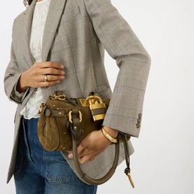 Model carrying Chloe Paddington Suede Shoulder Bag in Deep Khaki with gold-toned hardware, padlock charm and stud details, styled with grey blazer
