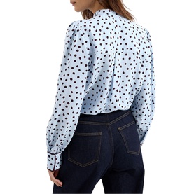Model wearing Phase Eight blue polka dot long sleeve blouse with pleat back detail, styled with dark indigo jeans, rear view.