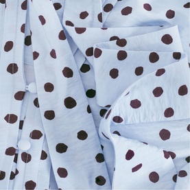 Phase Eight blue polka dot dress fabric detail, showing dark burgundy spots on pale blue woven material with ruffled texture.
