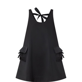 Damson Madder Cairo Open Back Mini Dress in black with tie-back detail, cargo pockets with bow trim, sleeveless, mini length