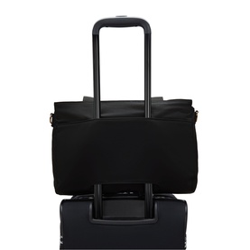 Kipling black tote bag with shoulder strap, shown mounted on a black rolling suitcase luggage handle