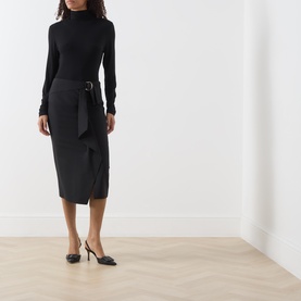 Model wearing Max Mara Studio Nero wool pencil skirt with belt detail and front split, styled with black roll-neck top and slingback heels.