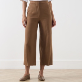 Model wearing Max Mara Studio Tobacco wool wide-leg cropped trousers, styled with a white top and tan loafers