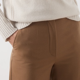 Model wearing Max Mara Studio tobacco wool trousers, close-up of front pocket detail, styled with a cream knit top