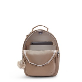 Kipling backpack in metallic rose gold, open to reveal padded laptop compartment, interior pockets, and signature monkey keyring charm.