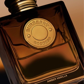 Burberry Goddess Amber Vanilla EDP in dark amber glass bottle with gold circular medallion cap, close-up detail shot