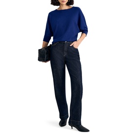 Model wearing Phase Eight blue batwing-sleeve knit top with dark indigo straight-leg jeans, styled with black heels and small clutch bag.