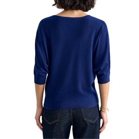 Model wearing Phase Eight blue elbow-sleeve knit top, back view, styled with blue jeans and gold bracelet