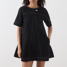 Model wearing Damson Madder black mini dress with contrast white stitching, short sleeves, and flared skirt with front button detail.
