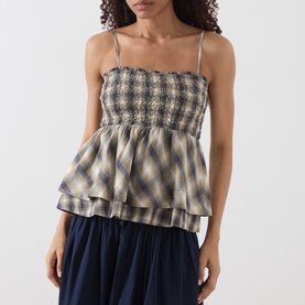 Model wearing Damson Madder Cardamon Check camisole top with shirred bodice, tiered peplum hem, thin straps, styled with navy skirt.
