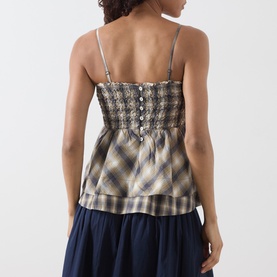 Model wearing Damson Madder camisole top in Cardamon Check, smocked bodice with button detail, spaghetti straps, back view, styled with navy skirt.