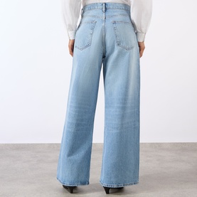 Model wearing FRAME DENIM Wide Leg Jeans in Dodger light blue wash, rear view, styled with a white blouse