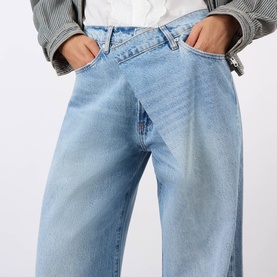 Model wearing FRAME DENIM Wide Leg Jeans in Dodger light blue wash, styled with a white top and grey striped jacket.