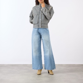Model wearing Isabel Marant Etoile grey cotton jacket with wide-leg light blue jeans and beige heeled boots.