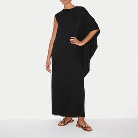 Model wearing Jigsaw black maxi dress with draped cape sleeve and frayed hem, styled with tan strappy flat sandals