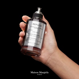 Maison Margiela REPLICA Lost Eden Eau de Parfum held in hand, large glass bottle with pump dispenser and label detail