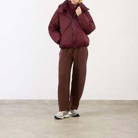Model wearing Adanola Logo Diamond Quilted Jacket in Damson Red with brown trousers and grey trainers.
