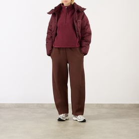 Model wearing Adanola Logo Diamond Quilted Jacket in Damson Red with matching hoodie, brown wide-leg trousers and white trainers.