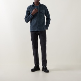 Model wearing Belstaff petrol casual shirt with chest pockets, styled with dark grey trousers and black leather shoes.