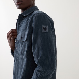 Model wearing Belstaff casual shirt in petrol corduroy with chest pockets and logo badge on sleeve.