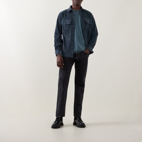 Model wearing Belstaff petrol casual shirt with chest pockets, styled with dark grey trousers and black leather shoes.