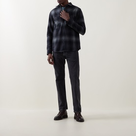 Model wearing Belstaff black cotton casual shirt with ombre check pattern, styled with dark grey jeans and black leather shoes