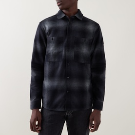 Model wearing Belstaff black cotton casual shirt in dark plaid check, featuring chest patch pockets and button-front placket