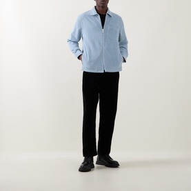 Model wearing Belstaff Mist Blue zip-up casual shirt with spread collar, styled with black trousers and black leather shoes.