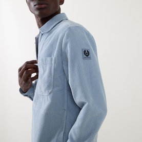 Model wearing Belstaff Mist Blue corduroy casual shirt with chest pocket and logo badge on sleeve.