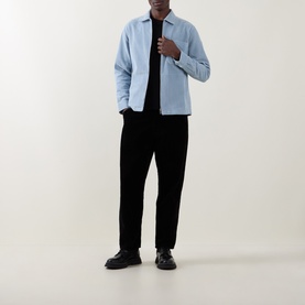 Model wearing Belstaff Mist Blue casual shirt, styled with black T-shirt, black trousers and chunky black shoes.