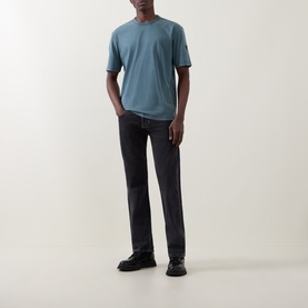 Model wearing Belstaff Crew Neck T in petrol blue, styled with dark grey jeans and black boots.