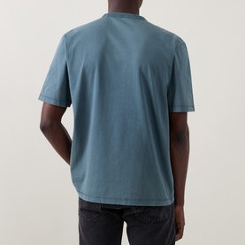 Model wearing Belstaff Crew Neck T in petrol blue cotton, shown from the back, paired with dark grey jeans.