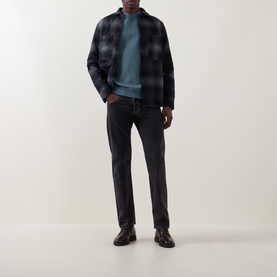 Model wearing Belstaff petrol cotton sweatshirt, styled with navy check overshirt and dark jeans