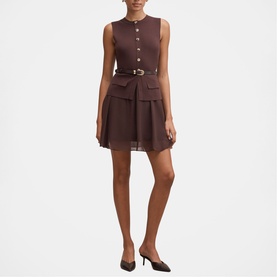Model wearing Forever New chocolate sleeveless mini dress with gold belt, patch pockets, and pleated skirt, styled with black heels.
