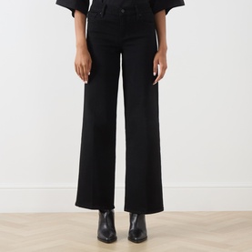 Model wearing FRAME DENIM Wide Leg Jeans in black, styled with black leather ankle boots. High-rise waist, wide-leg silhouette.
