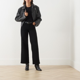 Model wearing FRAME DENIM black wide leg jeans, styled with a grey leather biker jacket and black ankle boots.