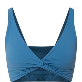 Free People Movement sports bra top in Riptide blue, featuring a deep V-neckline and front twist knot detail, smooth fabric finish