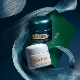 La Mer Day & Night Skincare Routine Gift Set featuring two moisturiser pots and signature dark green gift box with teal ribbon backdrop